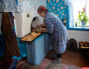Бабушка печет пироги в печке